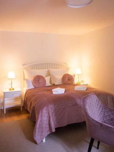 a bedroom with a large bed with two lamps at ApartOne Land-Hotel in Sebnitz