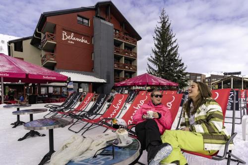 two people sitting in chairs in the snow at Hôtel Les 2 Alpes L'Orée Des Pistes in Les Deux Alpes