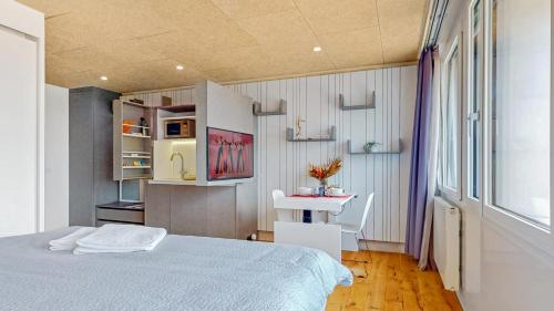 a bedroom with a bed and a table and a window at Evi's Home Hotel & Apartments in Bern