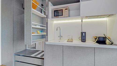 a kitchen with white cabinets and a sink at Evi's Home Hotel & Apartments in Bern