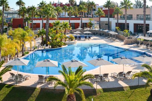 an overhead view of a large swimming pool with umbrellas at Vitors Village in Ferragudo