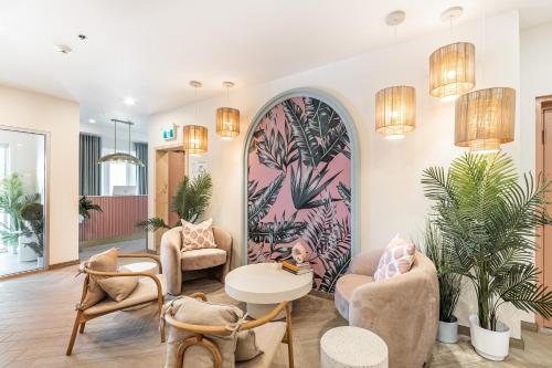 a lobby with chairs and a table and a mural at Hôtel le Rosay in Venise-en-Québec
