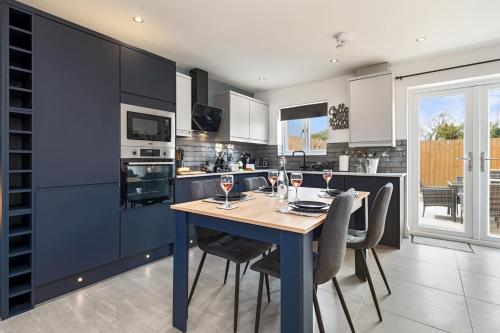 a kitchen with a table with wine glasses on it at Birch Cottage in Tenby