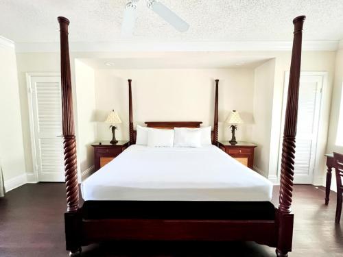 a bedroom with a large bed with white sheets at La Casa Hotel in Fort Lauderdale