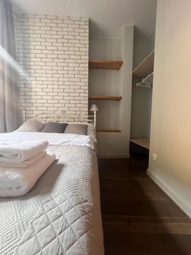 1 dormitorio con cama blanca y pared de ladrillo en Old Town Apartment, en Cracovia