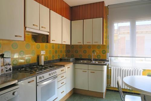 una cocina con armarios blancos y un horno de fogón blanco en Ca La Rosita, en Sant Jaume de Llierca