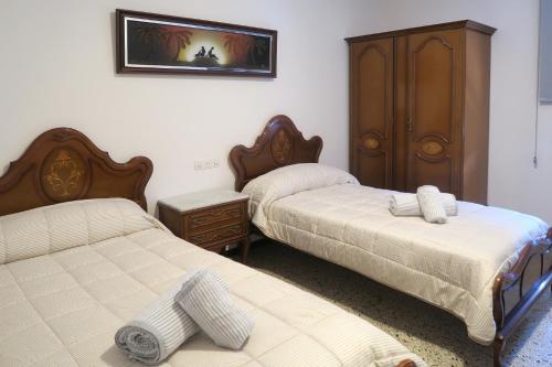 1 Schlafzimmer mit 2 Betten und einem Schrank in der Unterkunft Ca La Rosita in Sant Jaume de Llierca