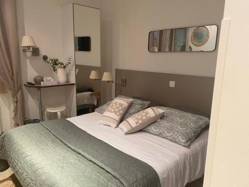 una camera da letto con un letto grande con due cuscini di Hôtel Restaurant de Londres a Saint-Just-en-Chevalet