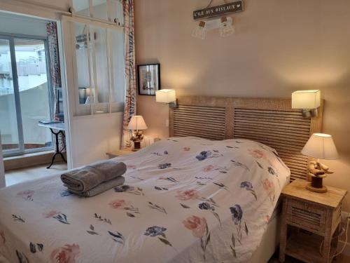 une chambre avec un lit avec un couvre-lit fleuri dans l'établissement Superbe Vue mer T2bis Arcachon, à Arcachon