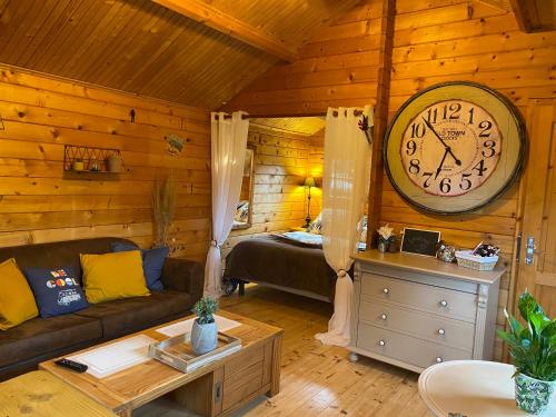 a living room with a large clock on the wall at Au chalet Fleuri in Ablon