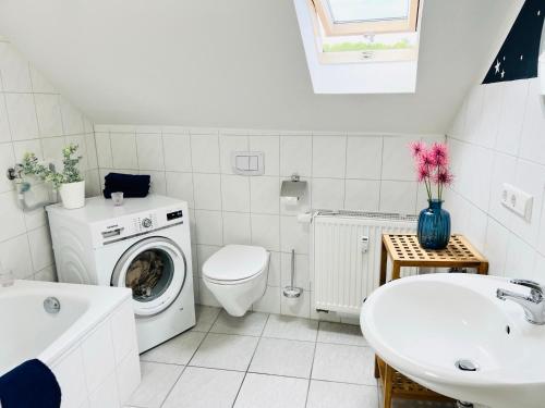 baño blanco con lavadora y lavamanos en Ferienwohnung Luna -3 Schlafzimmer, Waschmaschine, Küche, WLAN, ca 15 Min bis zum Europa Park,, en Malterdingen