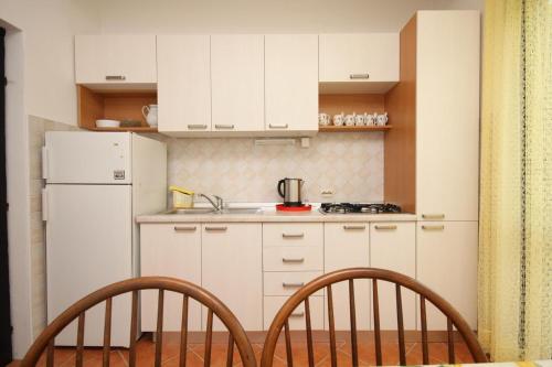a kitchen with white cabinets and a white refrigerator at Apartments and rooms by the sea Starigrad, Paklenica - 6588 in Starigrad