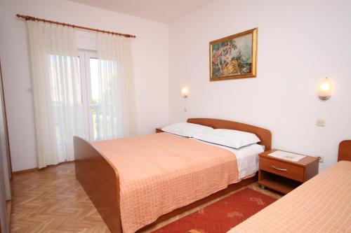 sypialnia z dwoma łóżkami i obrazem na ścianie w obiekcie Apartments by the sea Vlasici, Pag - 6523 w mieście Povljana