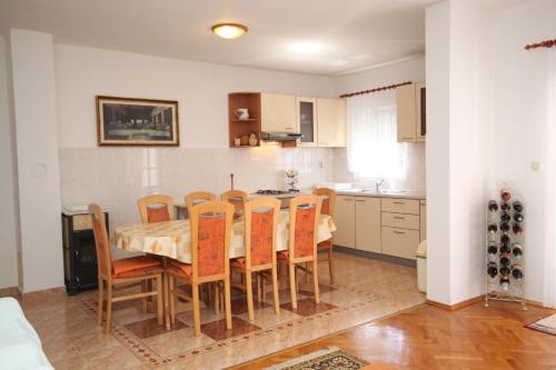 kuchnia i jadalnia ze stołem i krzesłami w obiekcie Apartments by the sea Vlasici, Pag - 6523 w mieście Povljana