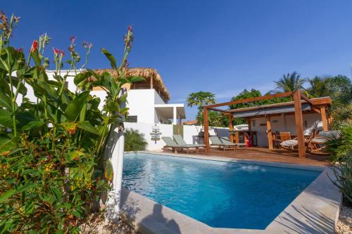 a villa with a swimming pool and a house at Woodz Bonaire in Kralendijk