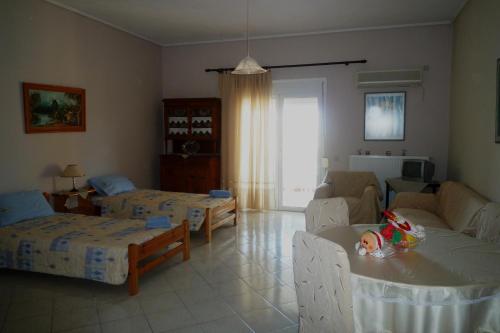 Kleidas Apartments في Thymianá: غرفة معيشة بسريرين وطفل على طاولة
