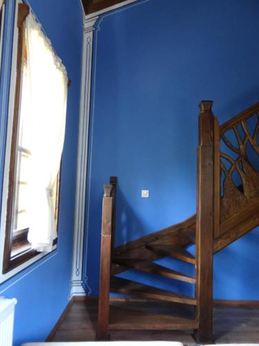 a blue room with a bed and a mirror at Недкова къща in Koprivshtitsa