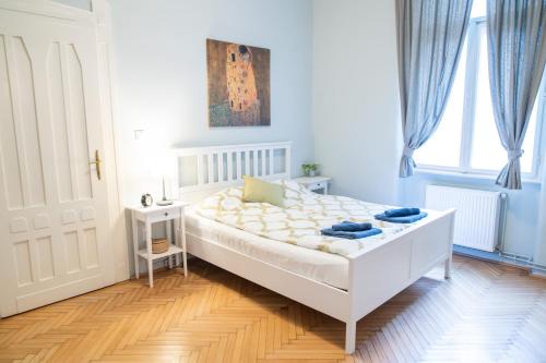 um quarto com uma cama branca e uma janela em Super Comfort Apartment With 3 Rooms Next To Opera em Budapeste