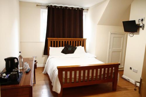 a bedroom with a bed and a desk and a window at The Bell and Bottle in Maidenhead