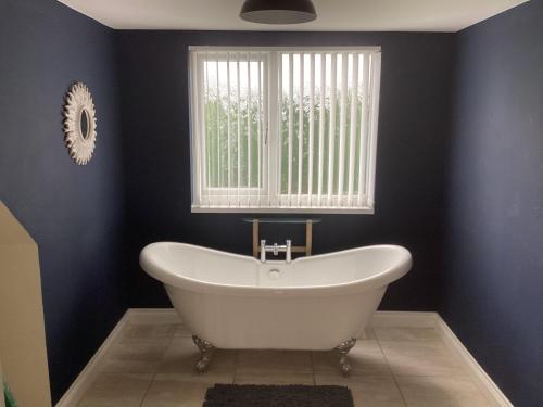 a white bath tub in a bathroom with a window at The hideaway in Stockton-on-Tees