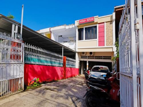 una motocicleta estacionada en un estacionamiento al lado de un edificio en Wisma Seruni Palopo en Palopo