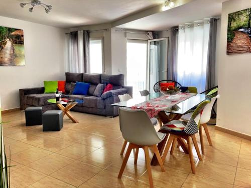 ein Wohnzimmer mit einem Sofa, einem Tisch und Stühlen in der Unterkunft La Posada del Centro in Denia