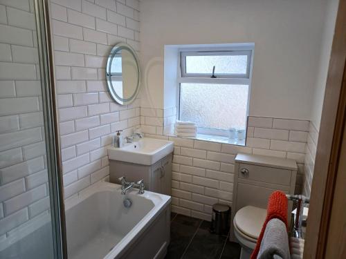 a bathroom with a tub and a sink and a toilet at Beachhaven116 Lovely beachside house Lower Largo in Lower Largo