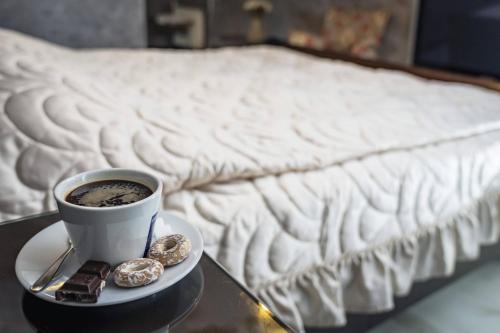 a cup of coffee and cookies on a table next to a bed at Villa ROYAL CLUB 13 in Jūrmala