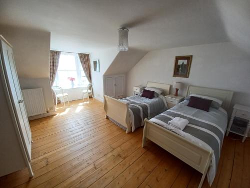 a bedroom with two beds and a wooden floor at Beachhaven116 Lovely beachside house Lower Largo in Lower Largo
