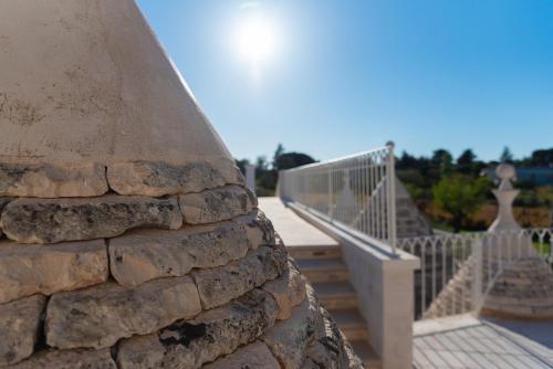 a close up of a stone wall with a walkway at Borgo dei Lecci Puglia in Selva di Fasano