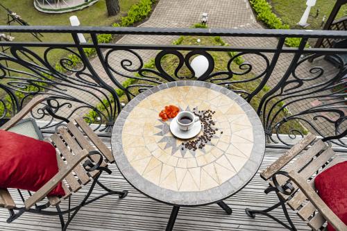 a table on a balcony with a cup of coffee on it at Villa ROYAL CLUB 13 in Jūrmala