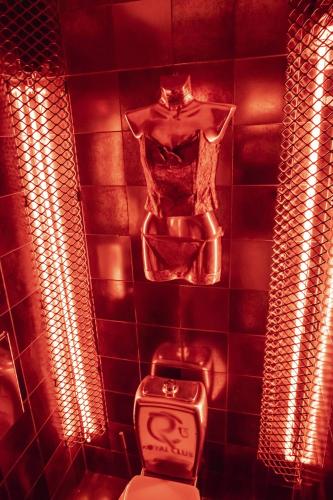 a red tiled bathroom with a toilet with lights at Villa ROYAL CLUB 13 in Jūrmala