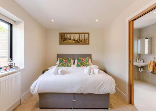 1 dormitorio con 1 cama con sábanas y almohadas blancas en Roe Cottage disabled adapted 2 bed cottage en Alcester