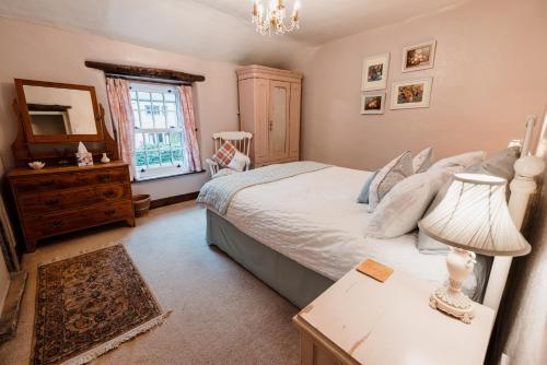 a bedroom with a bed and a table with a lamp at Beech croft holiday cottage in Castleton