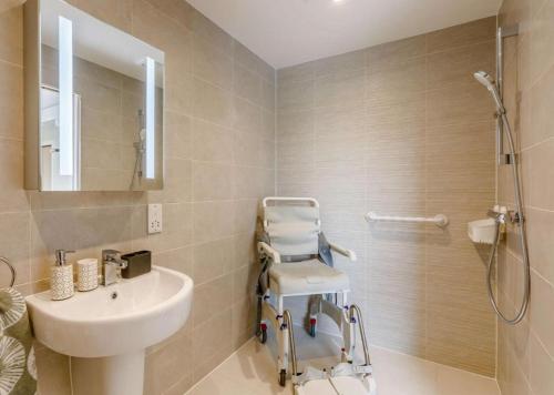 y baño con lavabo blanco y ducha. en Buck Cottage disabled adapted 3 bed cottage, en Alcester