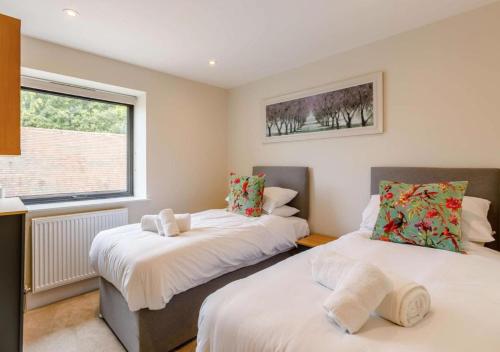 2 camas individuales en una habitación con ventana en Buck Cottage disabled adapted 3 bed cottage, en Alcester