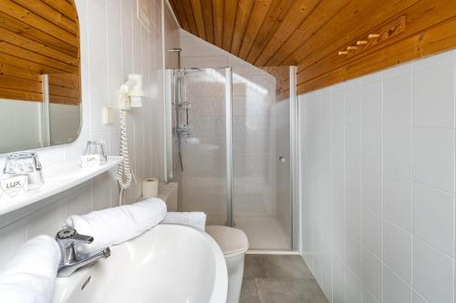 een badkamer met een toilet, een wastafel en een douche bij Gasthof-Appartements Sportalm in Bad Kleinkirchheim