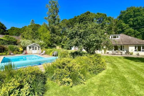 a yard with a swimming pool and a house at Bell Meadow in Coldwaltham