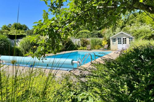 a swimming pool in a yard with a house at Bell Meadow in Coldwaltham