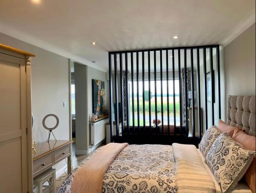 a bedroom with a bed and a large window at Poppy Annex in Wellow