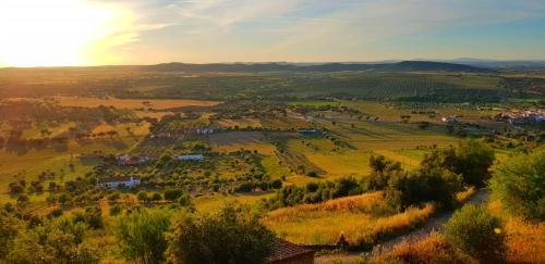 a small village in a valley with the sun setting at Charme de Monsaraz II in Monsaraz
