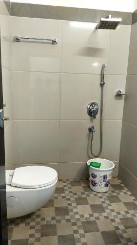 a bathroom with a toilet and a shower at Alfa Inn in Nedumbassery
