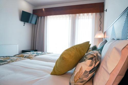 a hotel room with two beds and a window at Inn Caramulo Hotel in Tondela