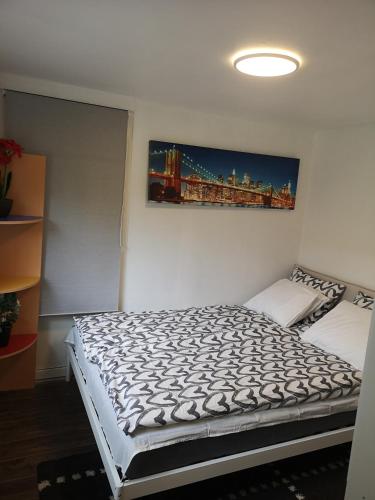 uma cama num quarto com uma pintura na parede em Minilägenhet em Gotemburgo