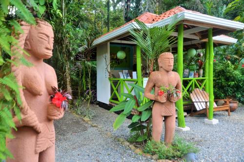 
a statue of a woman and a bear in front of a fire hydrant at Pachamama Jungle River Lodge - Punta Uva in Puerto Viejo
