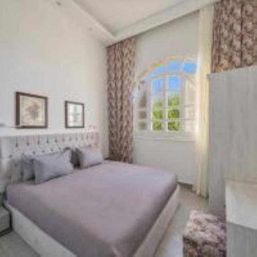 a bedroom with a white bed and a window at Golden Lake Marina Hotel in El Alamein
