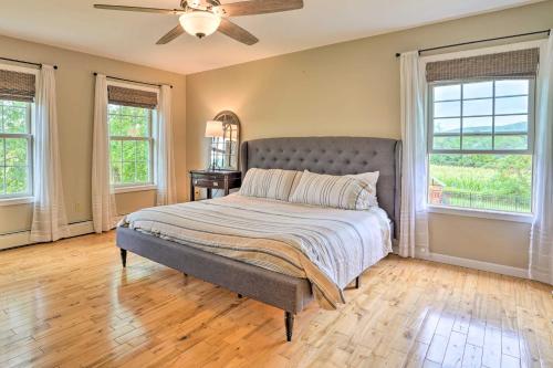a bedroom with a bed with a ceiling fan and windows at Lakefront Homer Abode with Patio and Backyard! in Homer