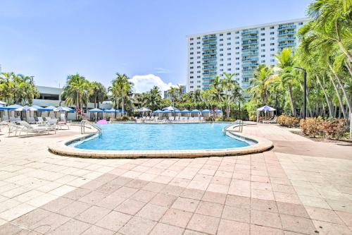 a swimming pool with palm trees and a building at Less Than Half-Mi to Beach Sunny Isles Resort Condo in Miami Beach