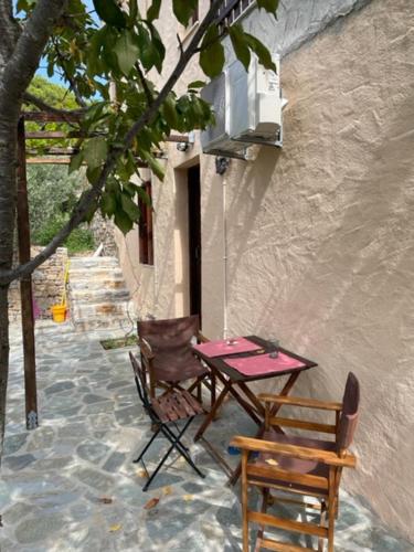una mesa y sillas sentadas junto a un edificio en Best location apt in Old town with walking distance to the beach, en Centro histórico de Alónnisos