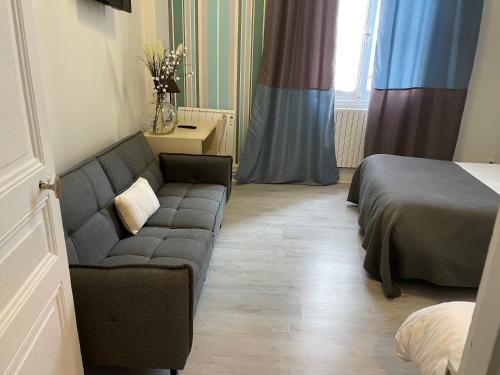 a living room with a couch and a bed at Hotel Au Chapon Fin in Poitiers